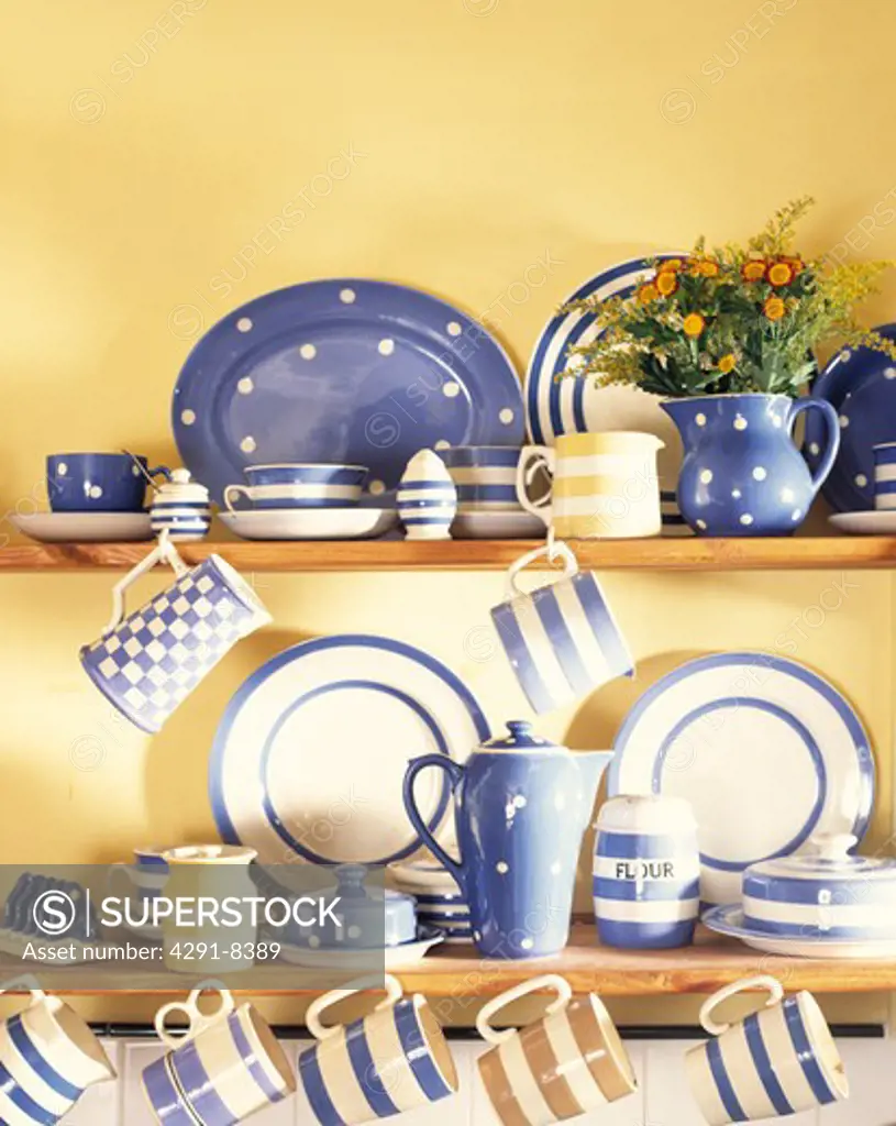 Collection of blue and white striped and spotted crockery on kitchen shelves