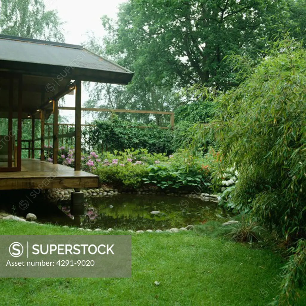 Japanese style covered veranda with round pebble edged pool Evergreen planting with bamboo