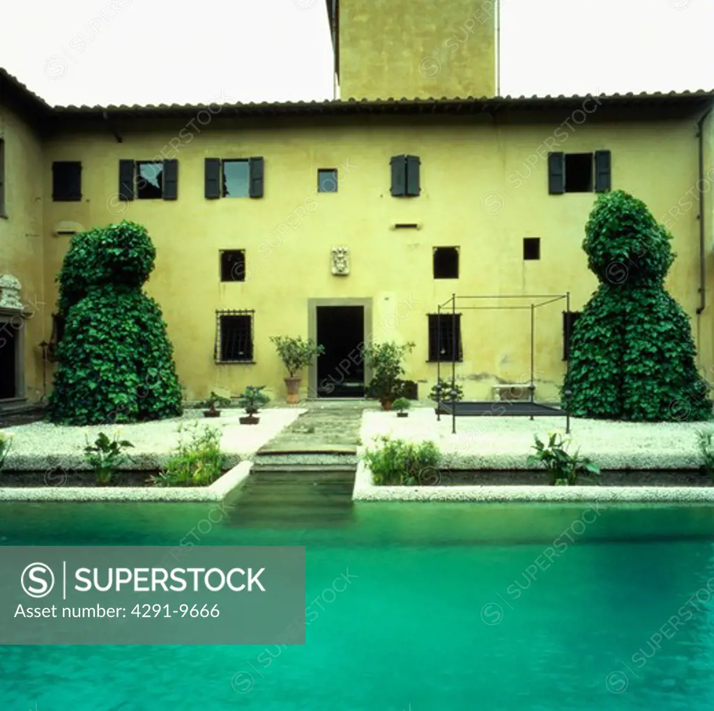 Swimming pool in front of large Italian villa