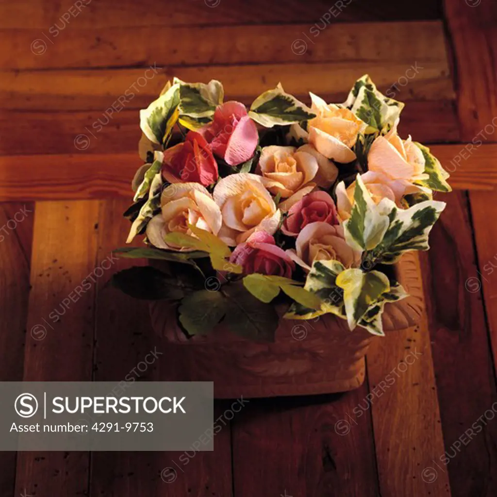 Still-Life of pink crepe paper roses with variegated ivy