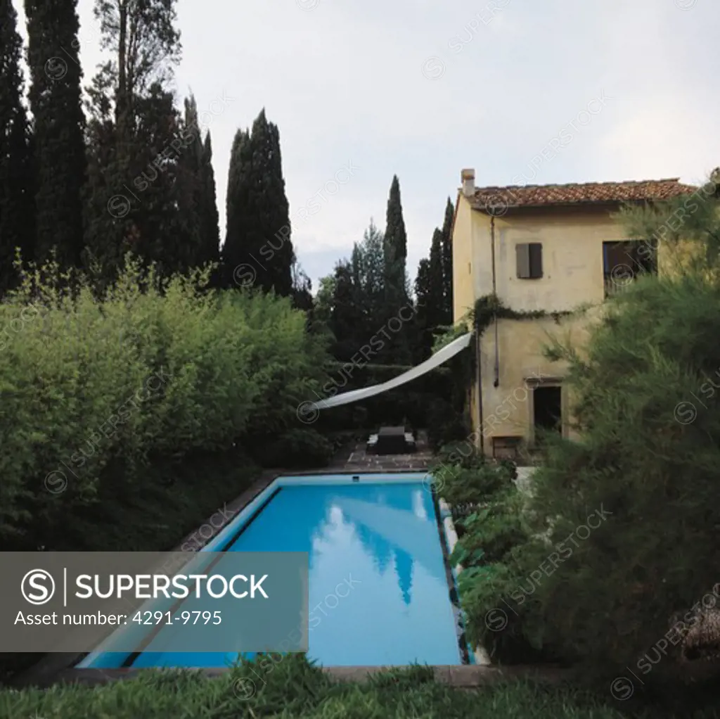 Rectangular swimming pool in garden of Italian country villa