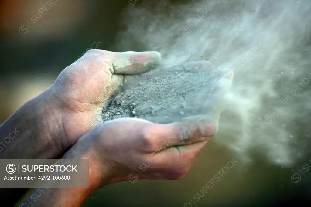 Sand blowing from man's hands