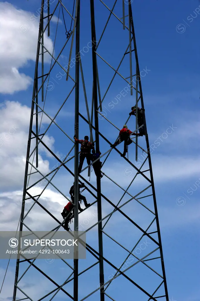 People working on pylon of power lines