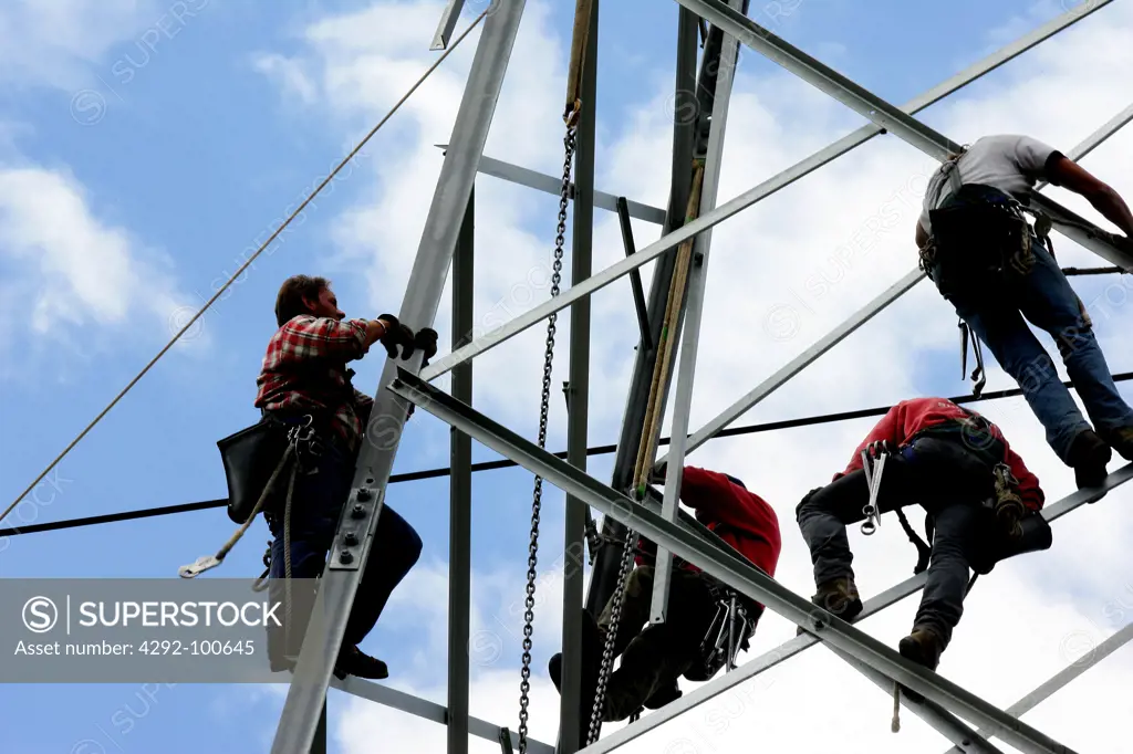 People working on pylon of power lines