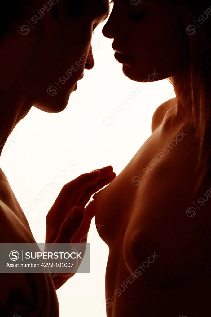 Man touching woman's naked breast