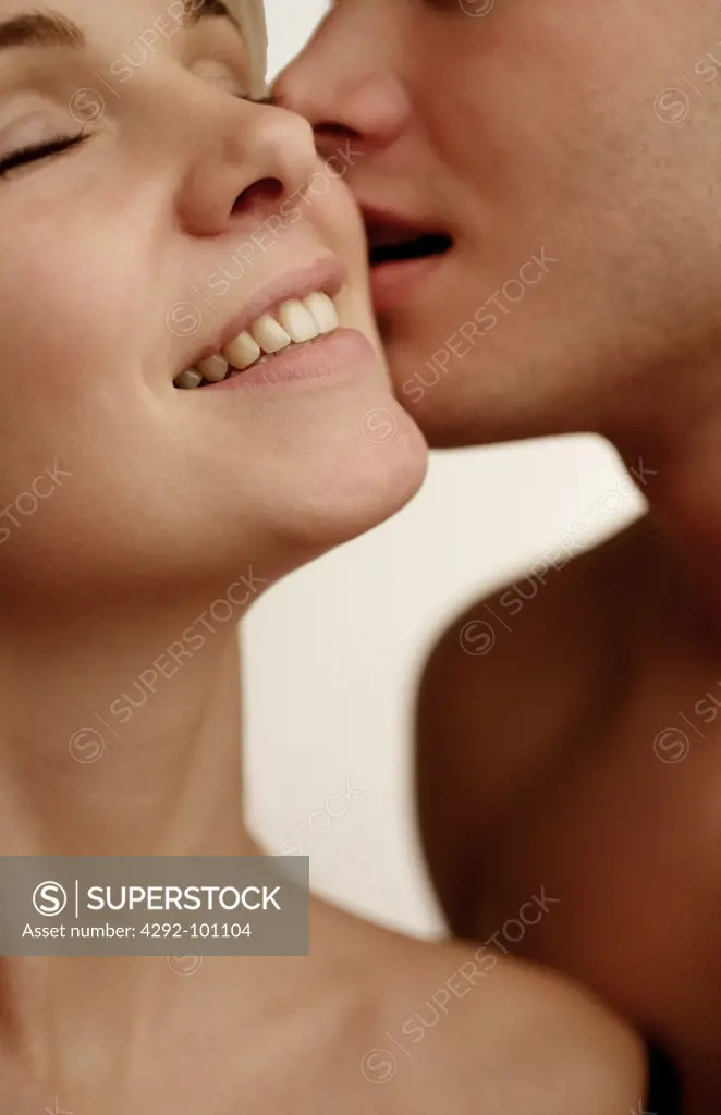 Close-up of young woman being kissed on the cheek