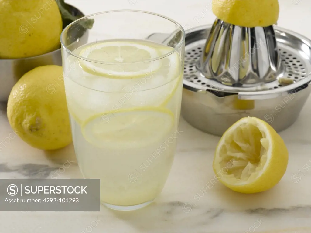 Glass of fresh lemonade ans juicer