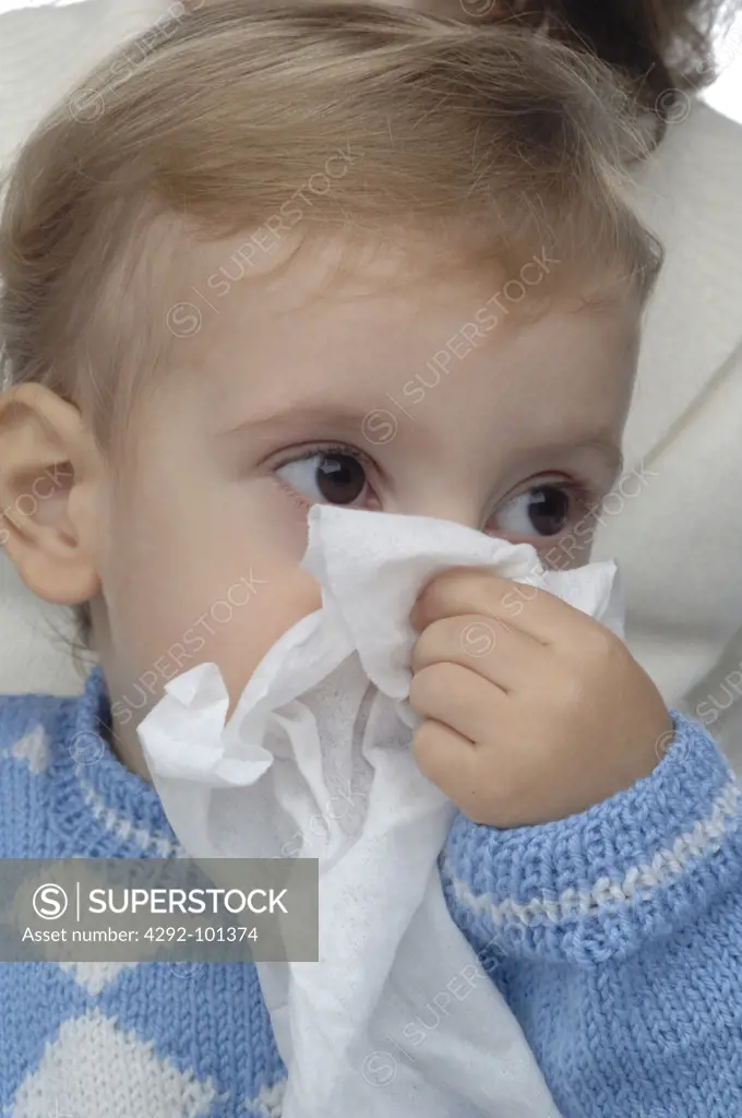 Boy with flu holding a handkerchief