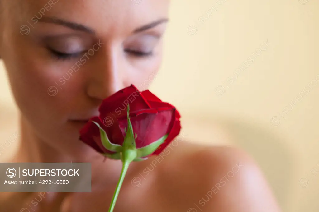 Young woman smelling rose