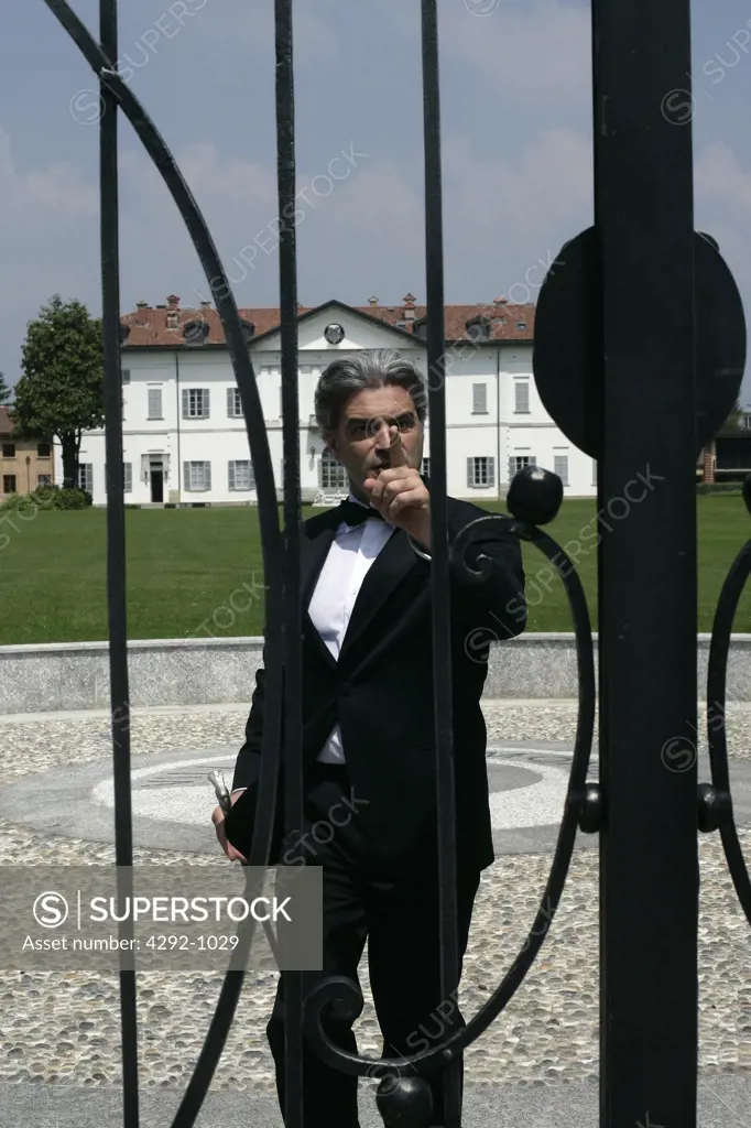 Mature man standing at villa gate