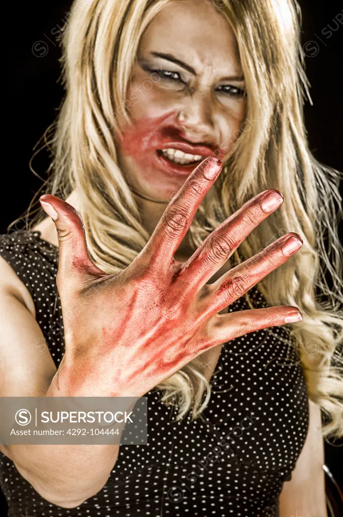 Woman's portrait with bloody hand and mouth