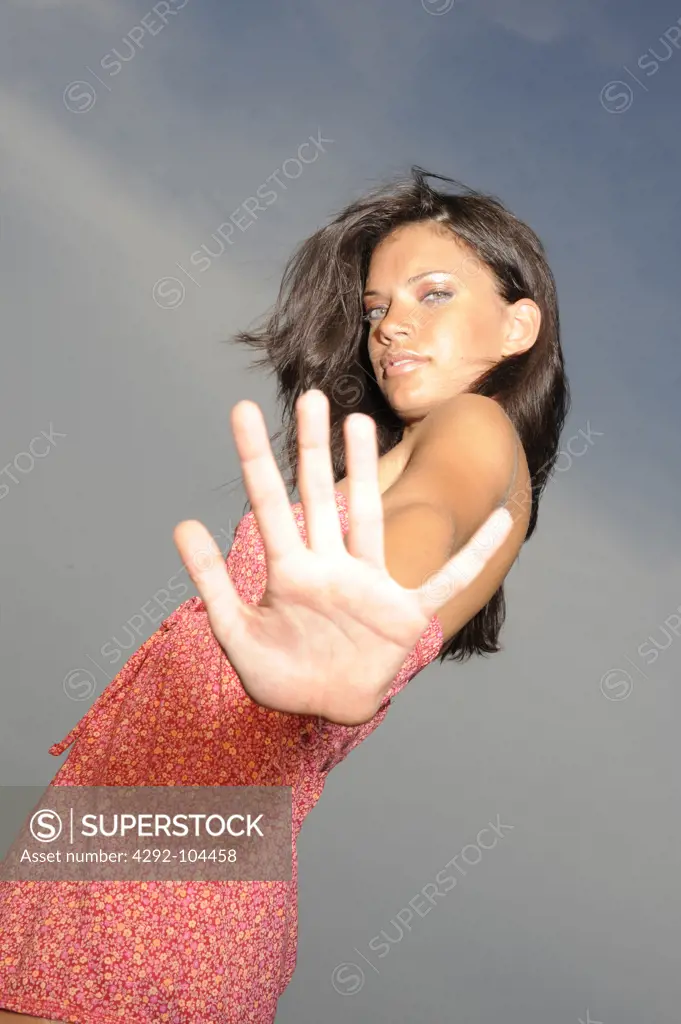 Portrait of woman doing stop sign