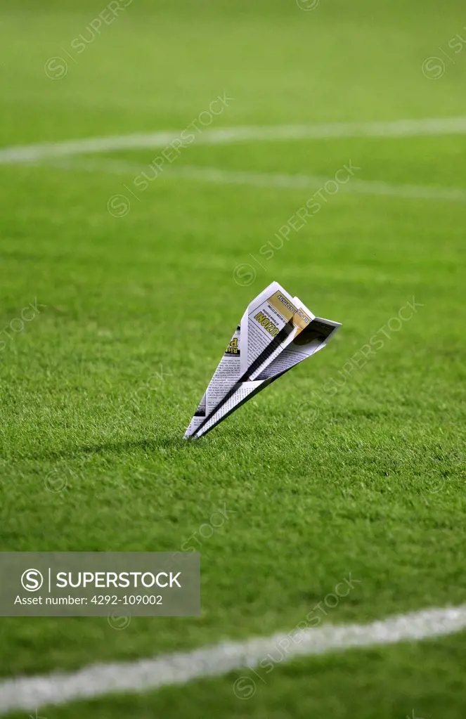 Paper airplane on soccer field