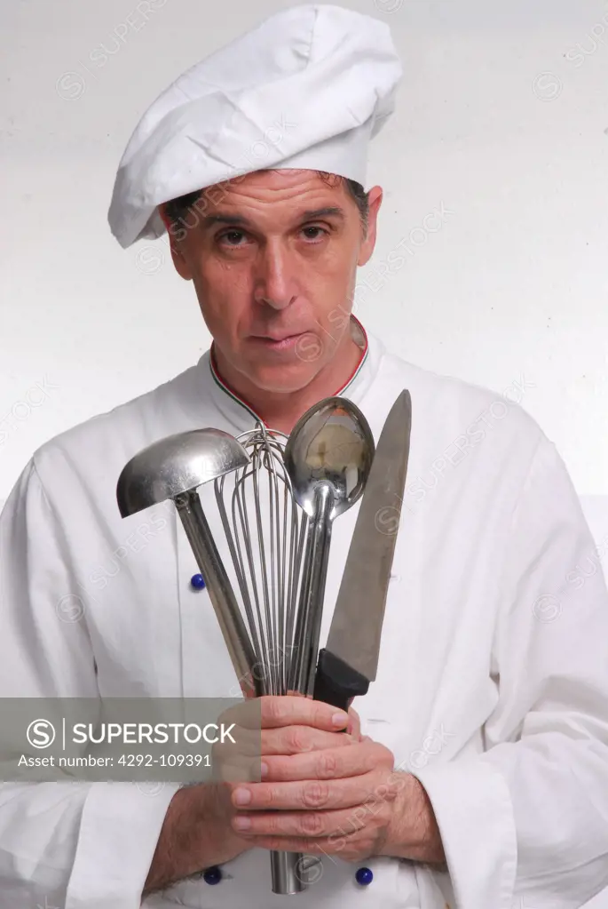 Portrait of male chef with kitchen utensils