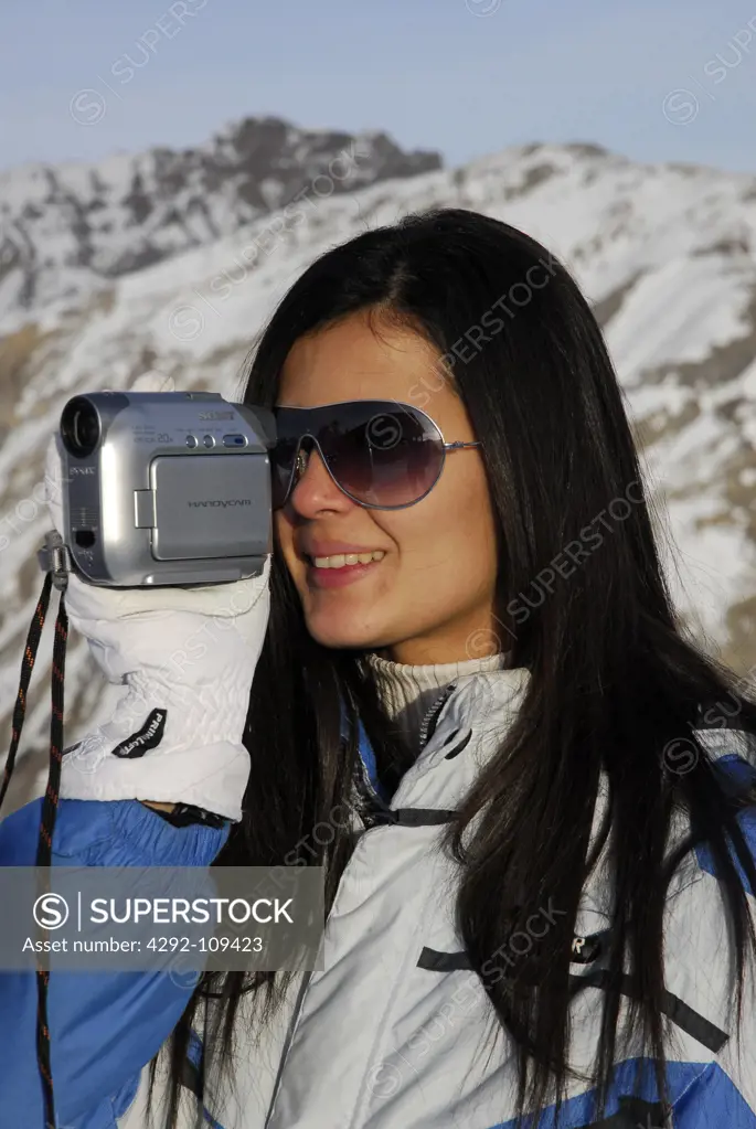 Woman at mountain using movie camera
