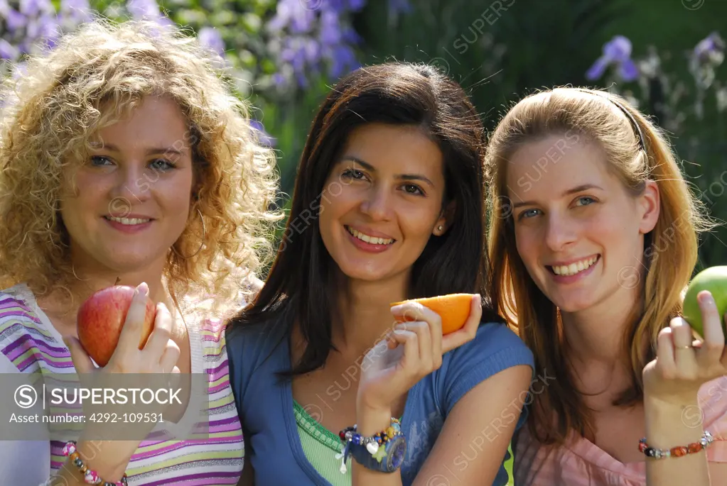 Portrait of a three friends with fruits