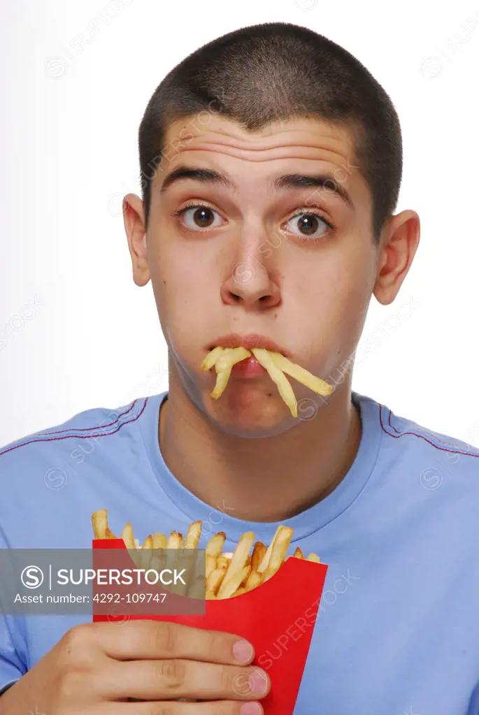 Teenage boy eating french fries