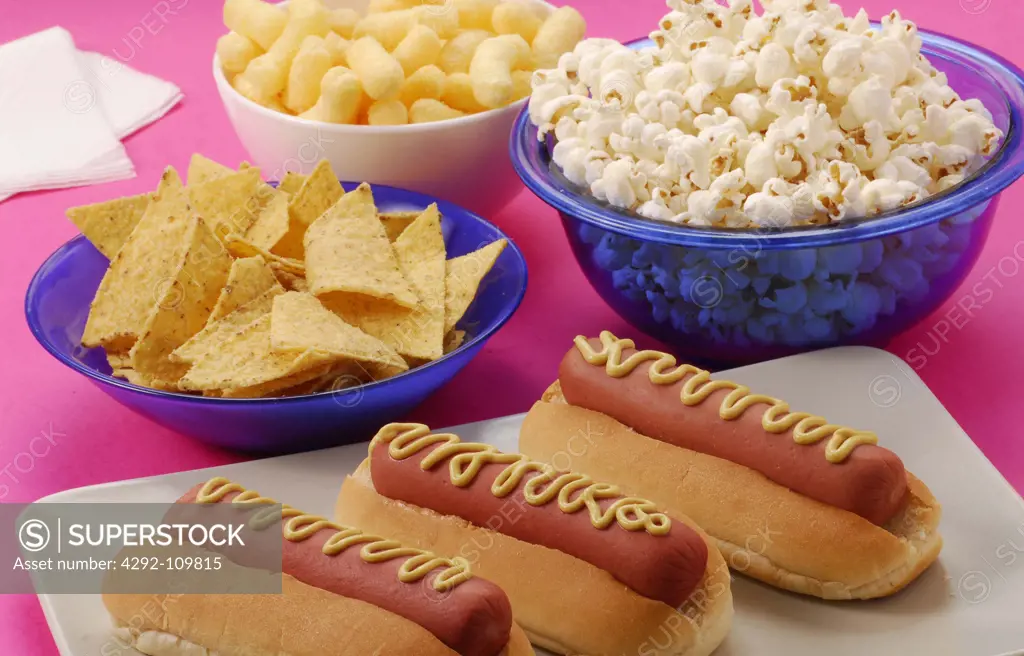 Hot Dogs in a Bun with Mustard and popocorn, nachos and snacks