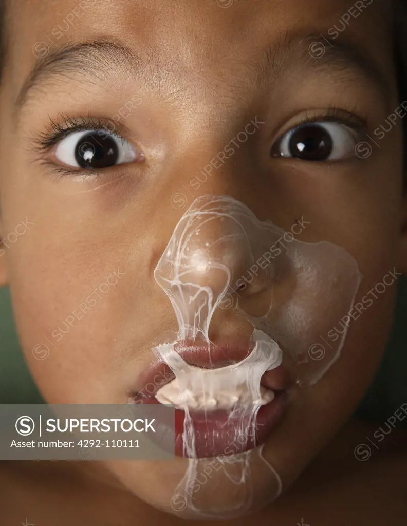 Boy with bubble gum on face