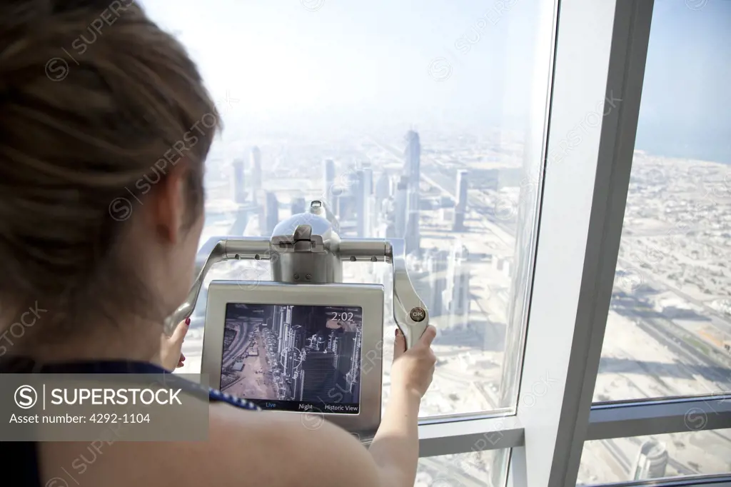 United Arab Emirates, Dubai, Woman Taking Pictures from the Observatory Floor of Burj Khalifa Tower