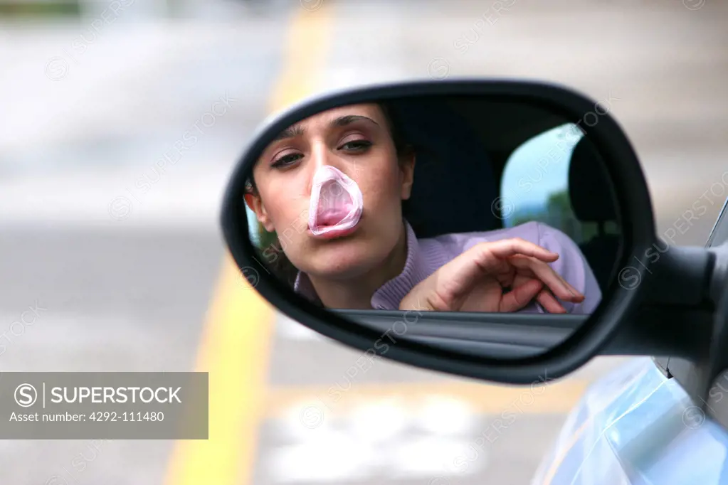 Woman in car with bubble gum on nose