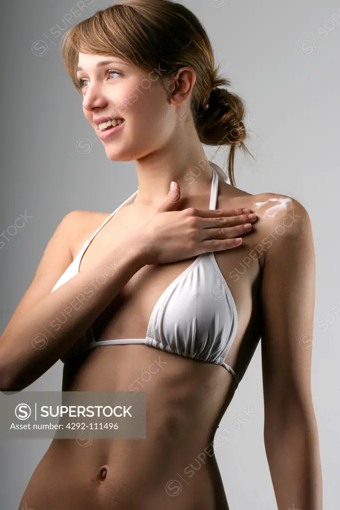 Woman applying moisturizer on shoulder