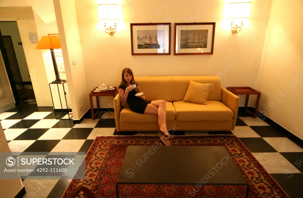 Young woman having tea in livingroom