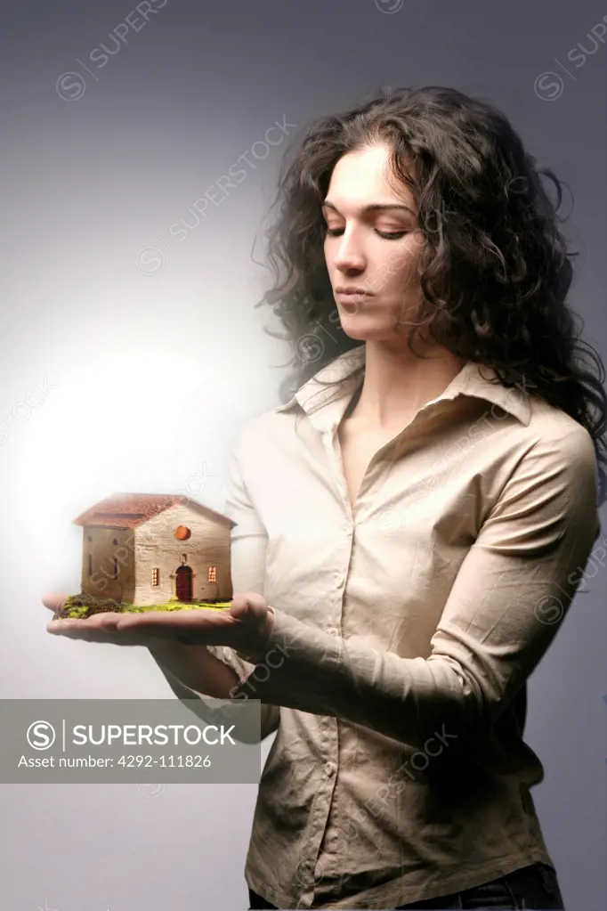 Woman holding a miniature house