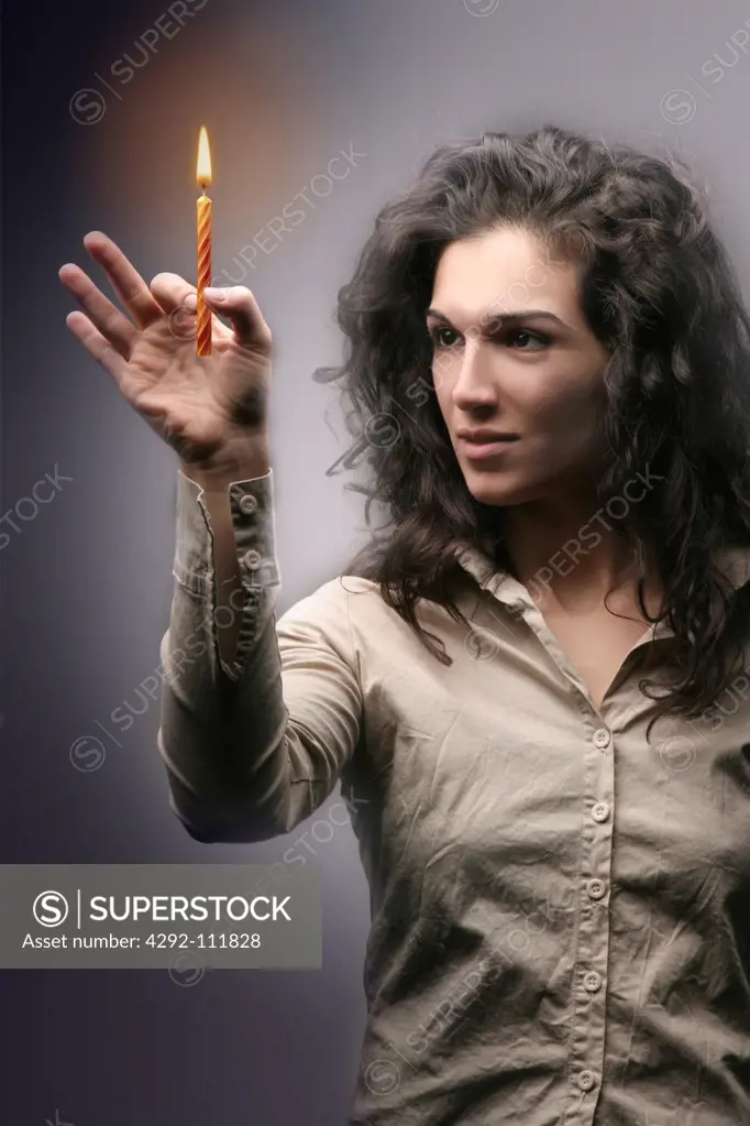 Woman holding a birthday lighted candle