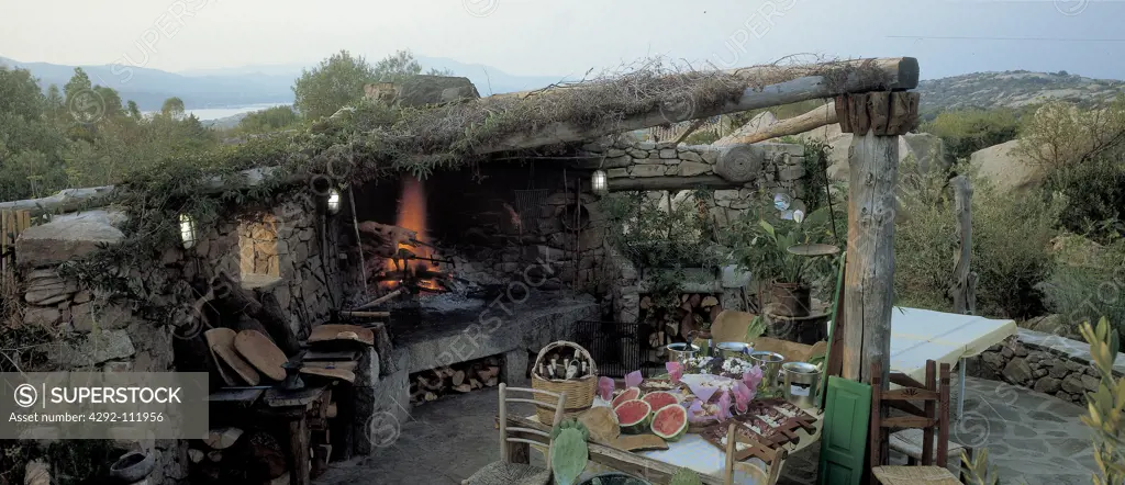 Italy, Sardinia, Stazzu (traditional house), pig cooking on granite barbecue