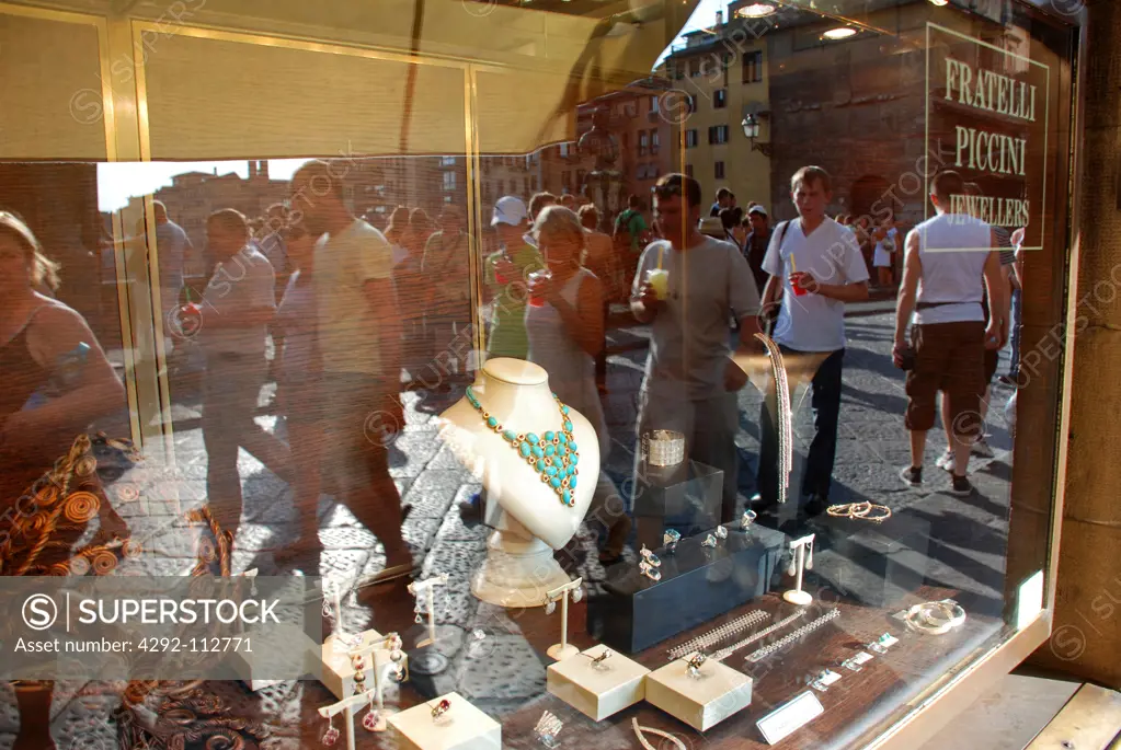 Italy, Tuscany, Florence, Ponte Vecchio bridge, A window display of jewellery and reflection of passerbys.