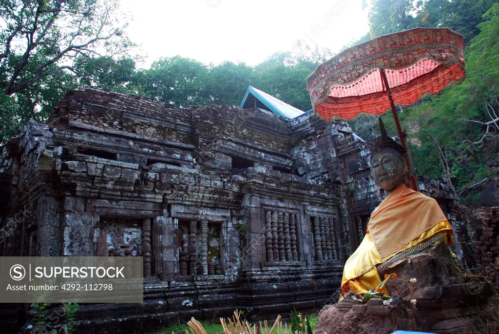Laos, Champasak, Statue of Buddha in Front of the Ruins of a Buddhist Temple.