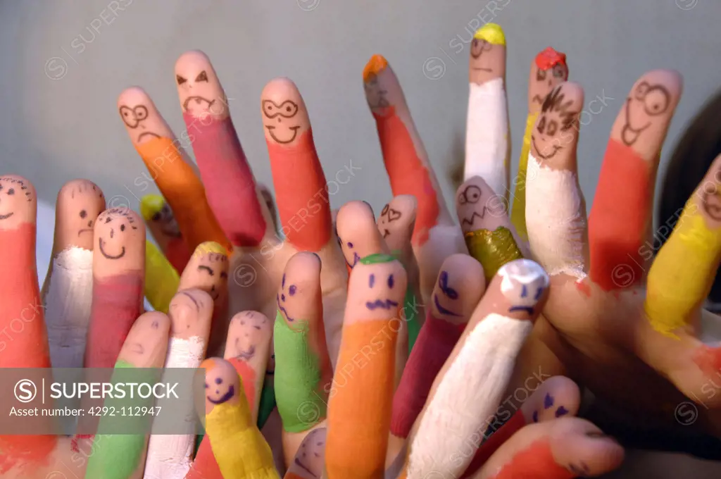 Faces drawn on coloured fingers