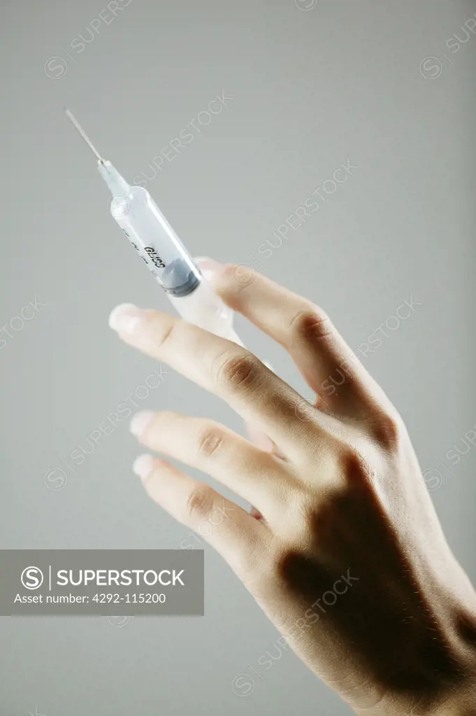 Woman's hand holding a syringe