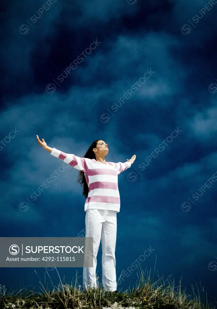 Woman standing outdoors with arms outstreched