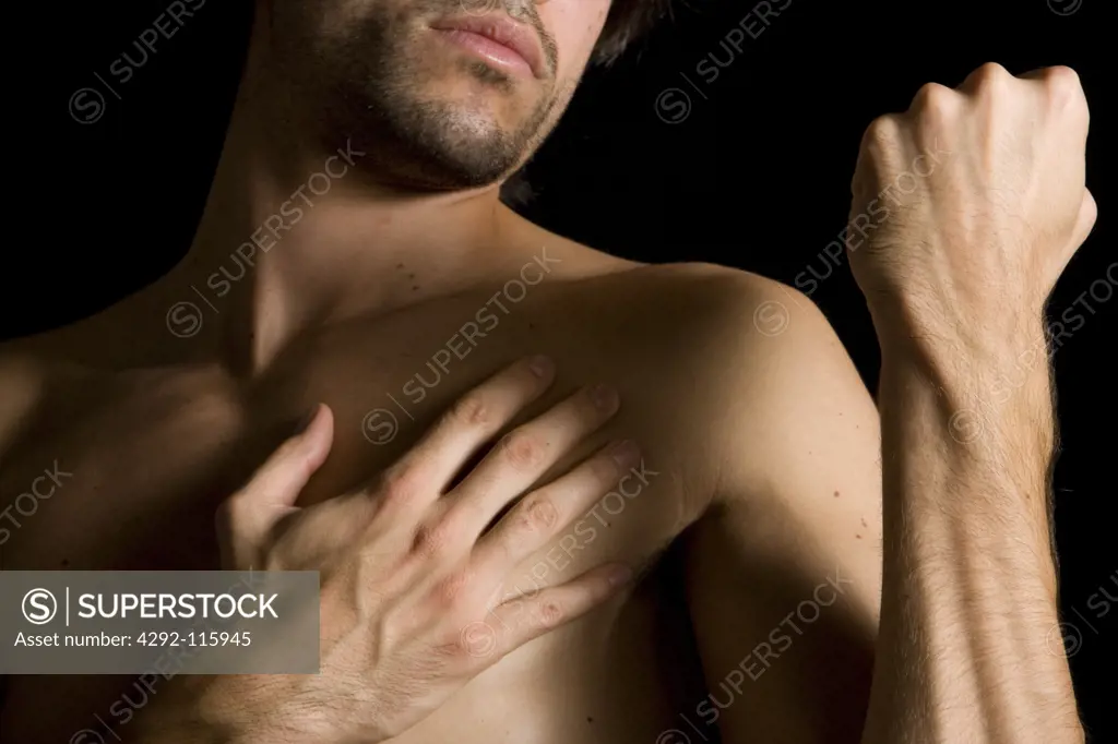 Studio shot of a naked man making fist