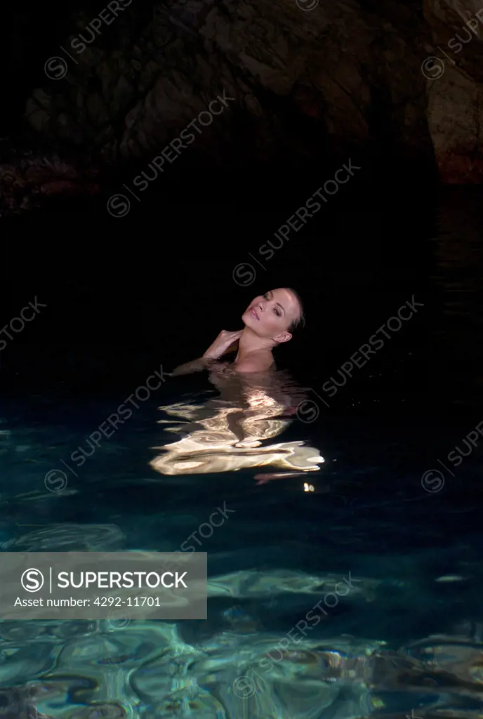 Italy, Tuscany, Elba Island, Cavoli cave, young woman swimming