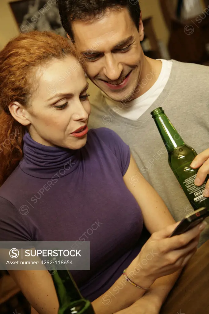 Couple in a bar looking at mobile