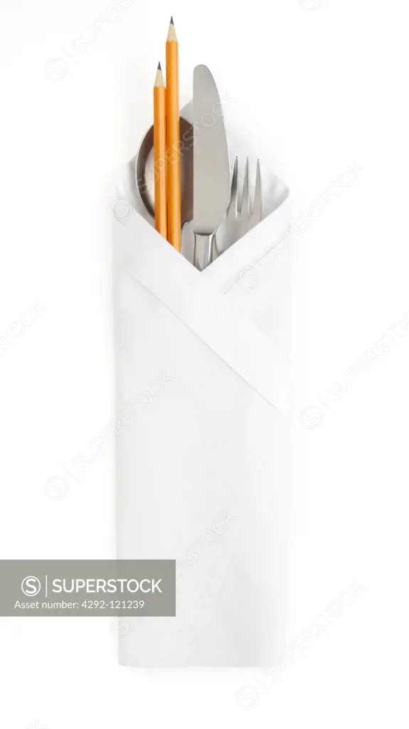 Cutleries and pencils wrapped in napkin