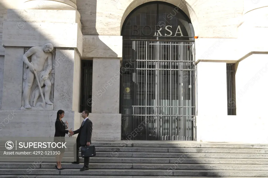Italy, Lombardy, Milan, the stock exchange in Piazza Affari. Businessman and businesswoman shaking hands