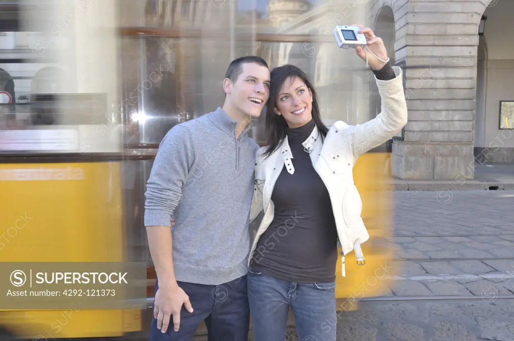 Italy, Lombardy, Milan, Piazza della Scala, couple taking picture of themselves with digital camera