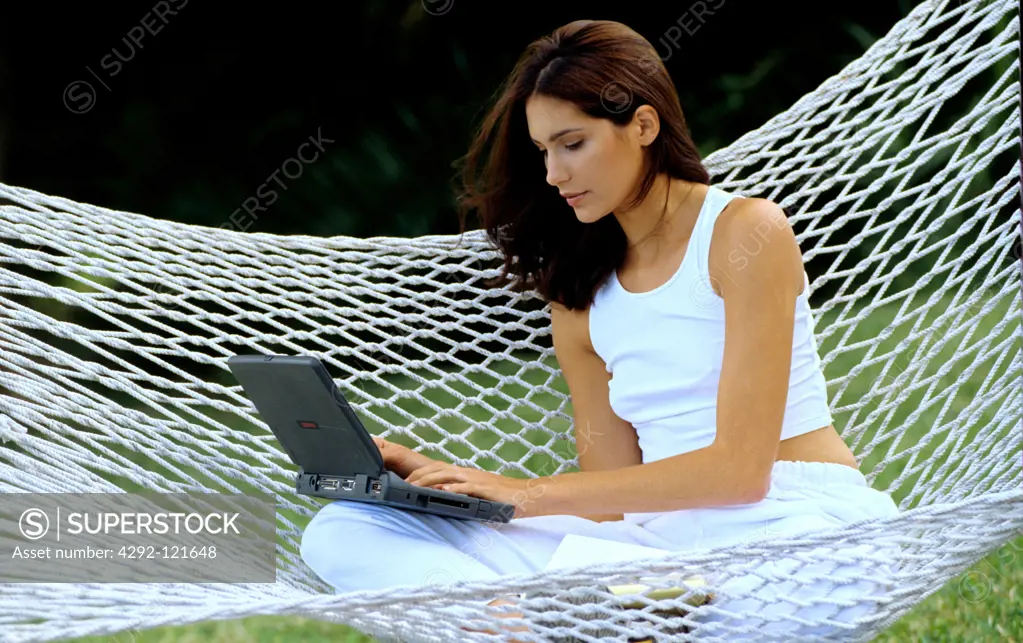 Woman with laptop in hammock