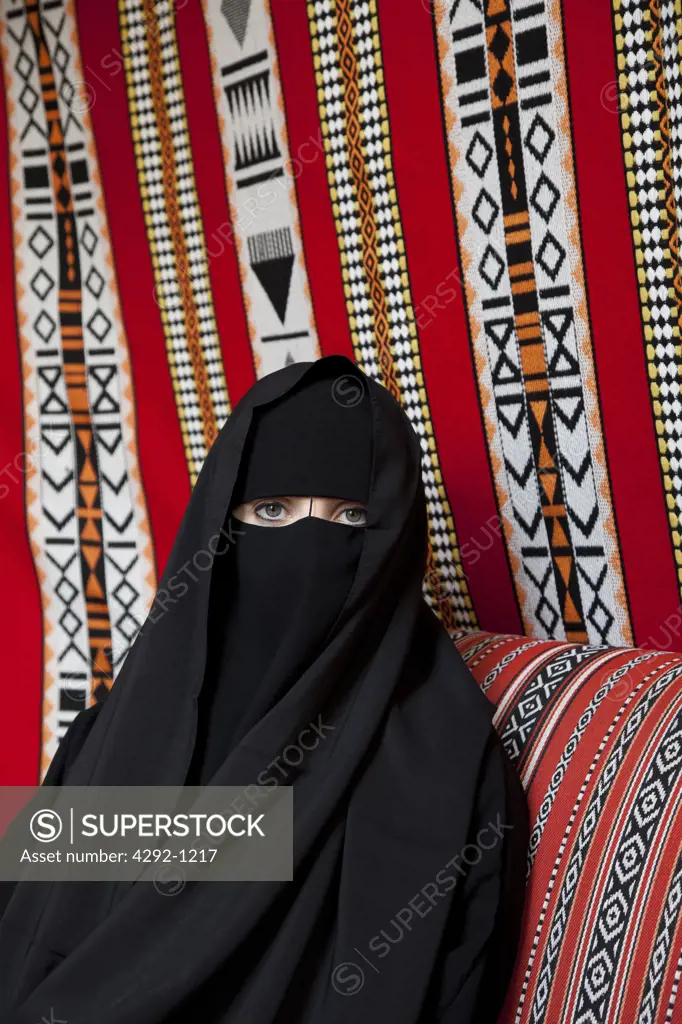 United Arab Emirates, Dubai, Arab Woman in a Hijab Sitting on Sofa