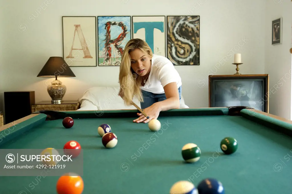 Young woman shooting pool.