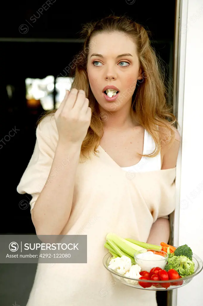 Young woman eating vegetables