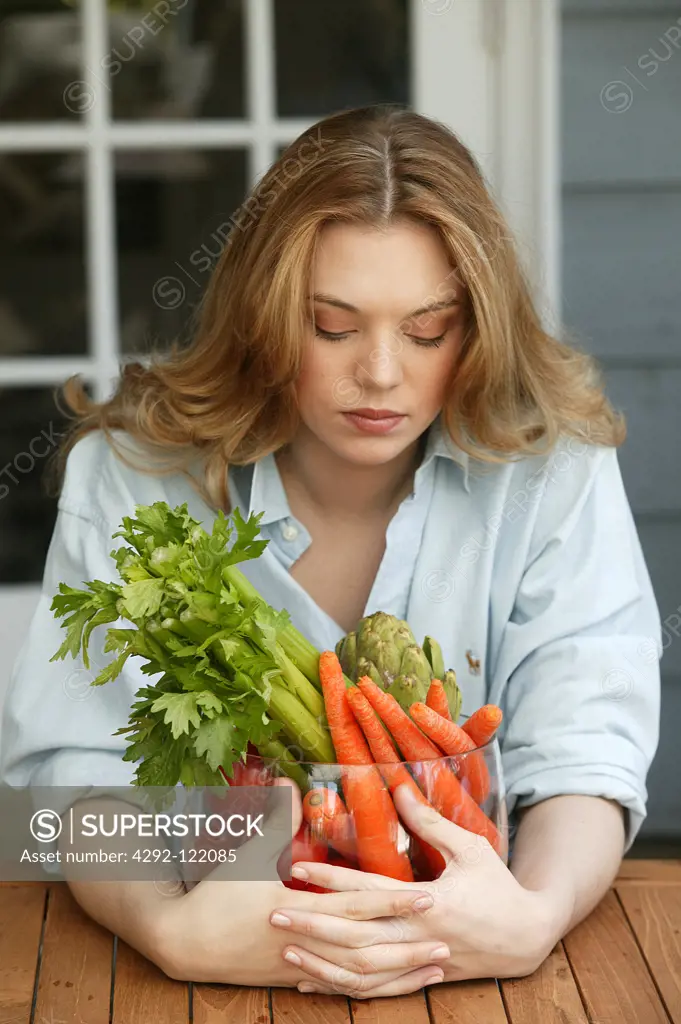 Young woman with vegetables bowl