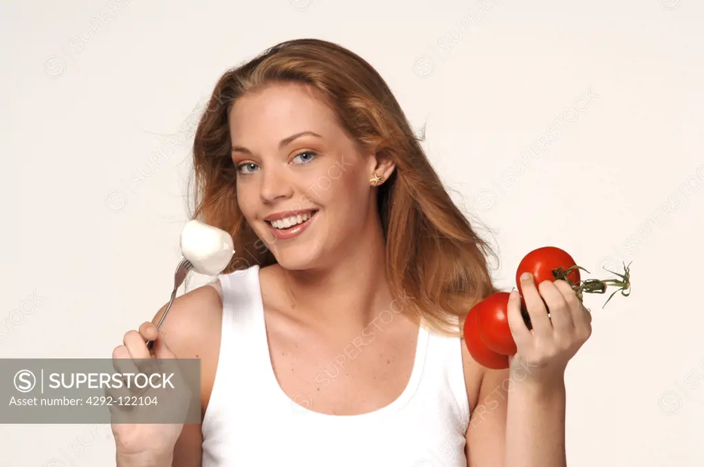 Young woman with tomatoes and mozzarella