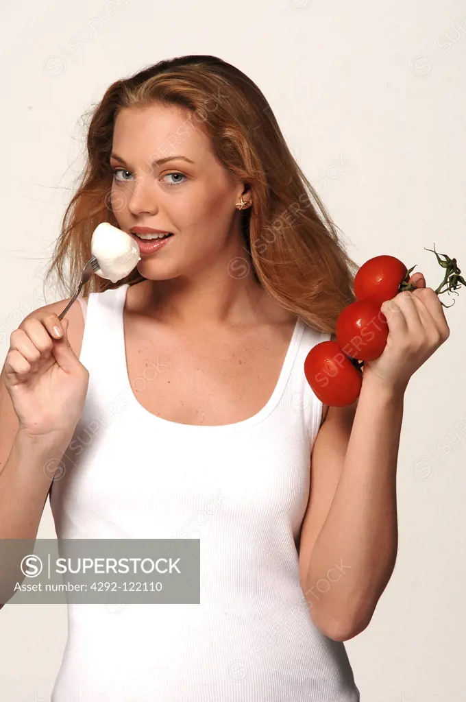 Young woman with tomatoes and mozzarella