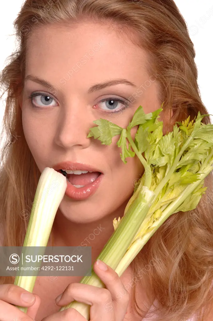 Young woman eating celery