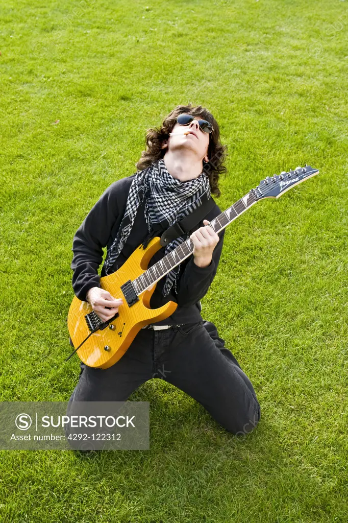 Teenage boy playing bass guitar